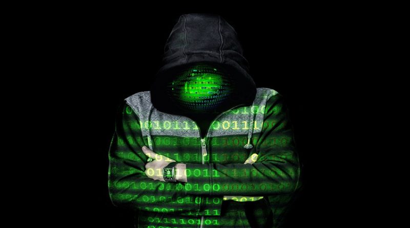 Image of hacker in shadows with code superimposed across body and face
