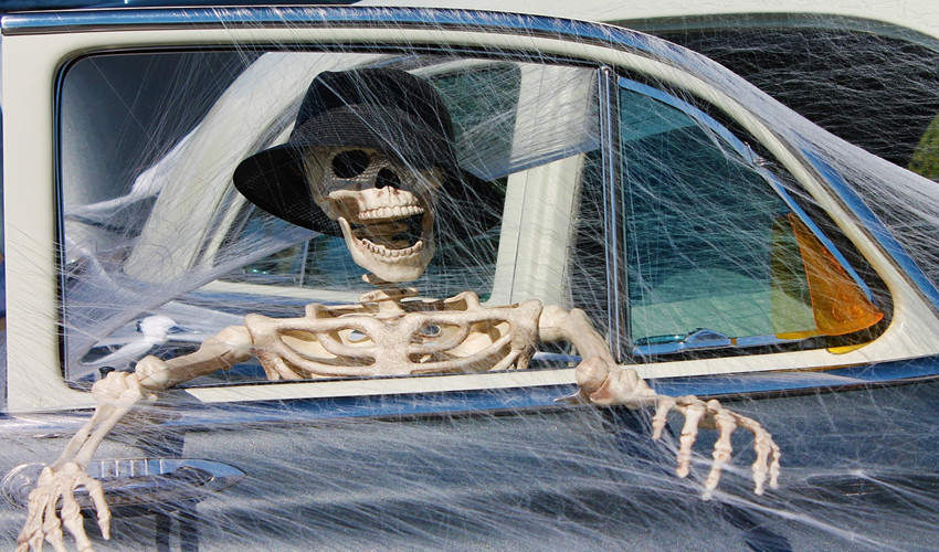 Skeleton wearing a hat sitting in a car