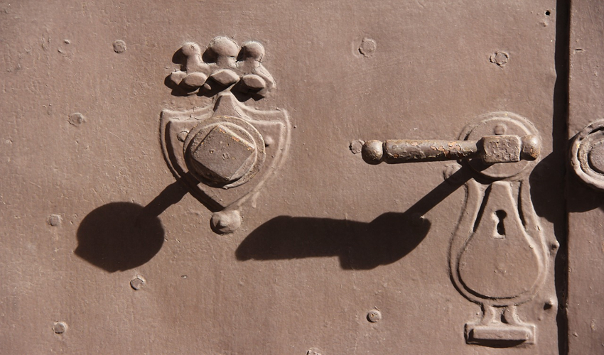 photo showing lock and door handle with shadows cast