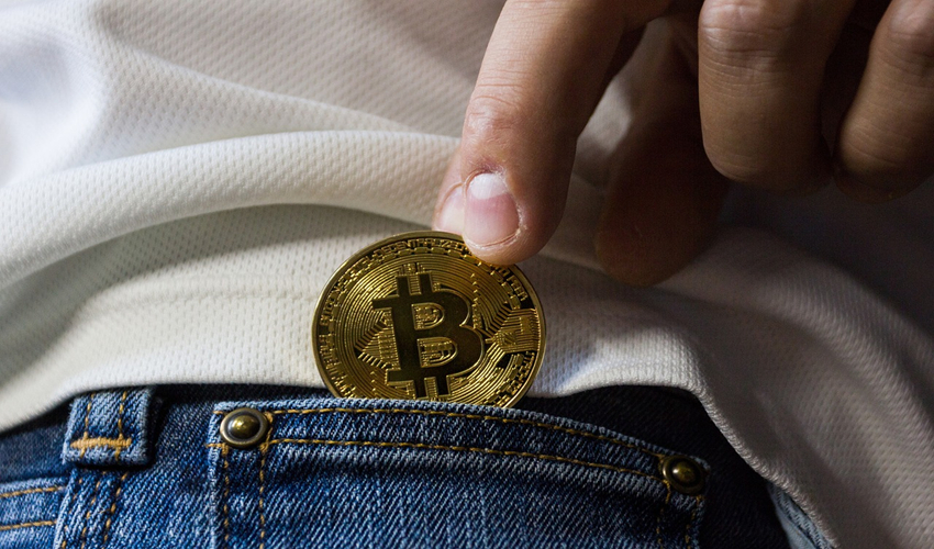Bitcoin being placed in jeans pocket