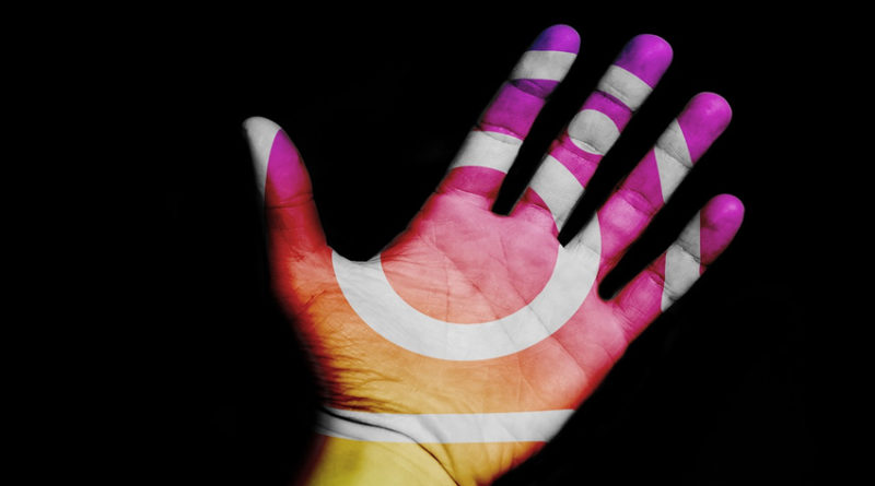 A hand with an Instagram logo projected onto it