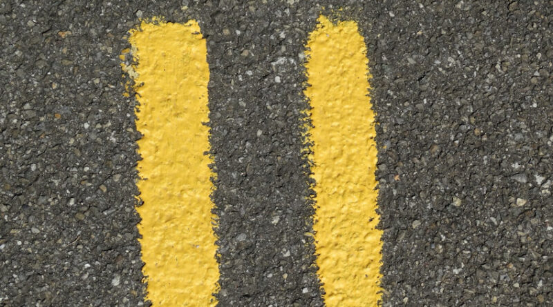 Number eleven painted in yellow on a tarmac road surface